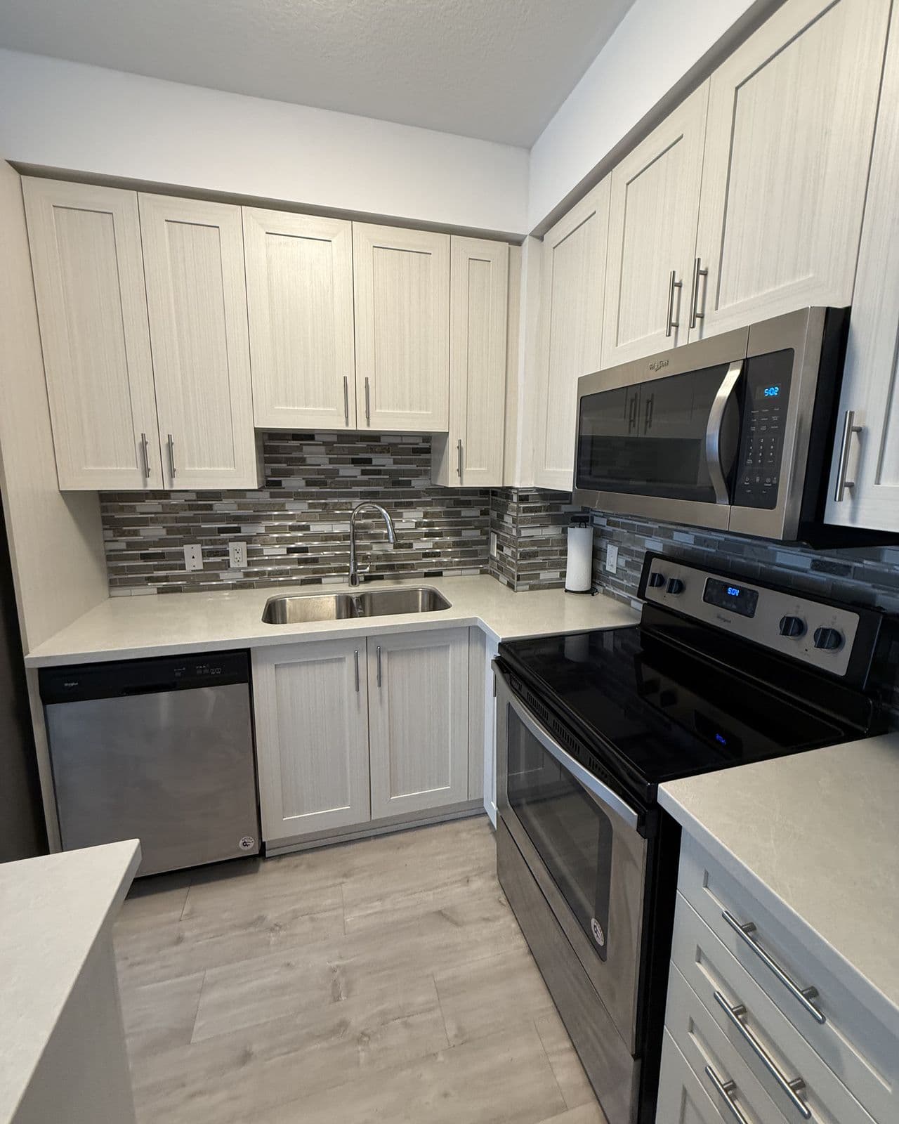 A bright, freshly cleaned kitchen with clear counters and swept floors